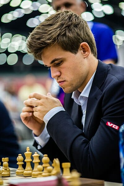 man looking at chess board